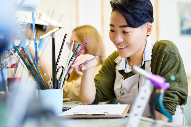 Mujer creativa alegre en taller