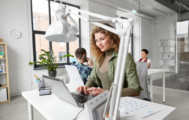 mujer creativa con computadora portátil trabajando en la oficina