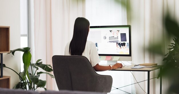 Mujer creativa diseñadora de sitios web en una computadora o PC de escritorio que trabaja en Internet SEO para una agencia de marketing digital Trabajo remoto desde casa chica o redactora independiente empleada de una empresa de tecnología en línea