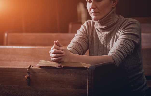 Mujer cristiana rezando en la iglesia.