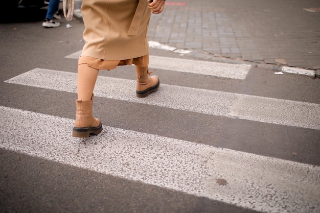 una mujer cruza la calle en un paso de peatones. mujer en la ciudad