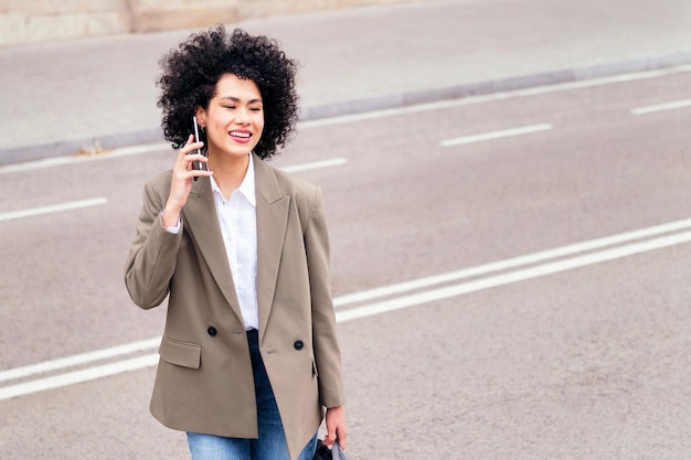 Mujer cruzando la calle y hablando por teléfono