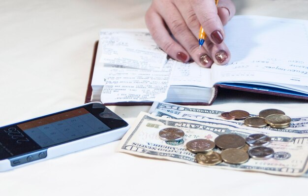 una mujer en un cuaderno toma notas y cuenta dinero