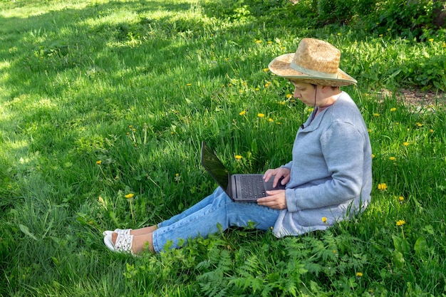 Una mujer de cuarenta y cinco años con gafas trabaja como independiente al aire libre