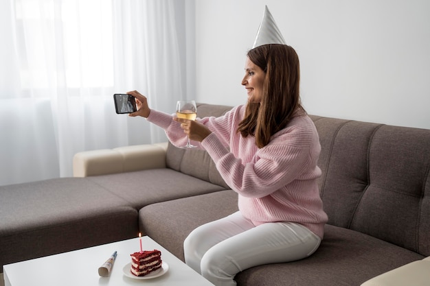 Foto mujer en cuarentena celebrando cumpleaños por teléfono