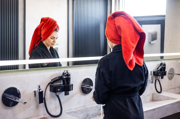 Mujer, en, cuarto de baño, secar el cabello