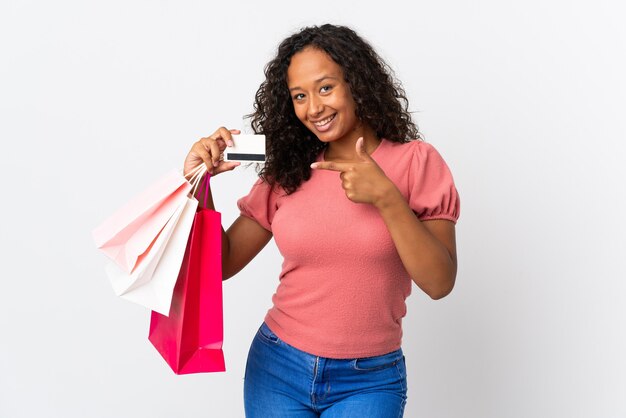 Mujer cubana aislada en blanco sosteniendo bolsas de la compra y una tarjeta de crédito