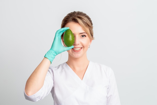 Mujer cubre los ojos con aguacate.