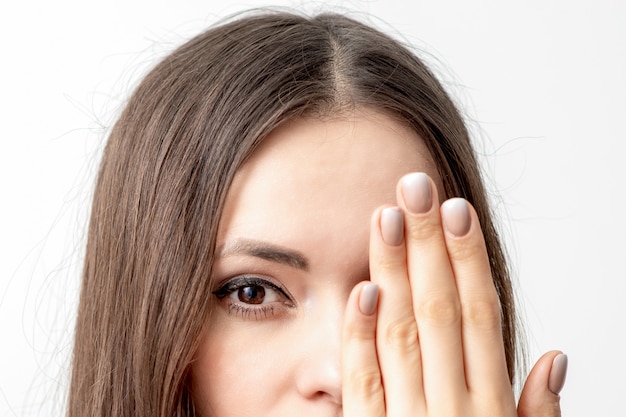 Mujer cubre su rostro con la mano.