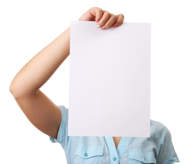 Mujer cubriendo su cara con una hoja de papel en blanco aislada en blanco