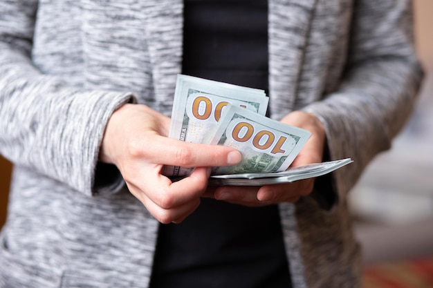 Mujer cuenta dinero manos femeninas tienen denominaciones de billetes en efectivo de 100 dólares en moneda