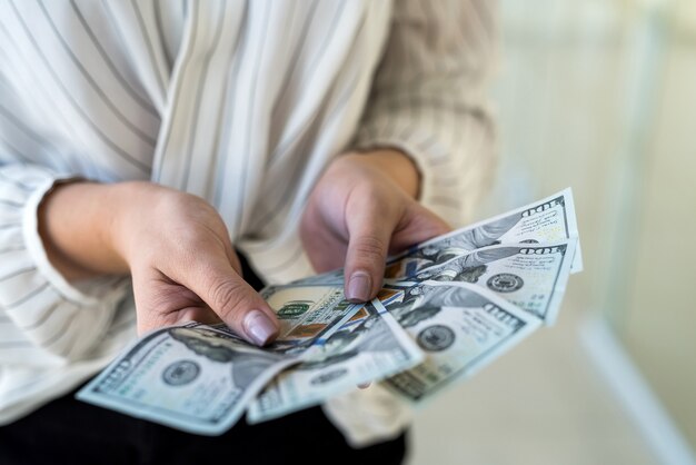 Foto mujer cuenta dólar estadounidense en el centro comercial