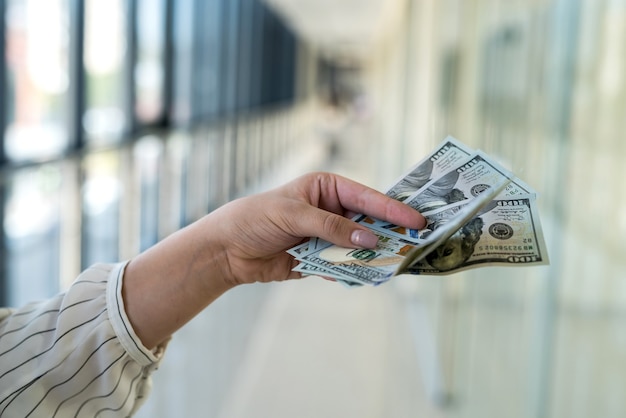 Mujer cuenta dólares en el centro comercial después de una compra exitosa