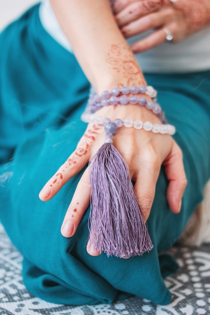 Mujer con cuentas de lila mala en sus manos henna mehendi
