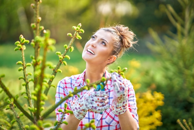 La mujer cuida las plantas en el jardín.