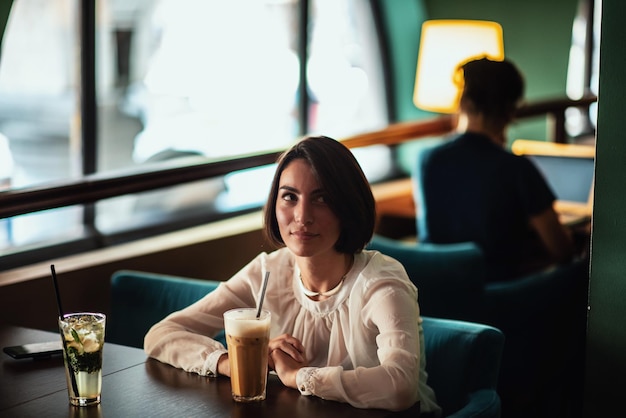 Mujer cuidadosa tomando café en una cafetería