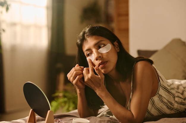 Mujer cuidando el área debajo de los ojos