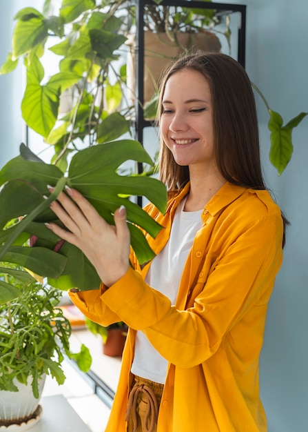 Foto mujer cuidando bien de las plantas de su casa