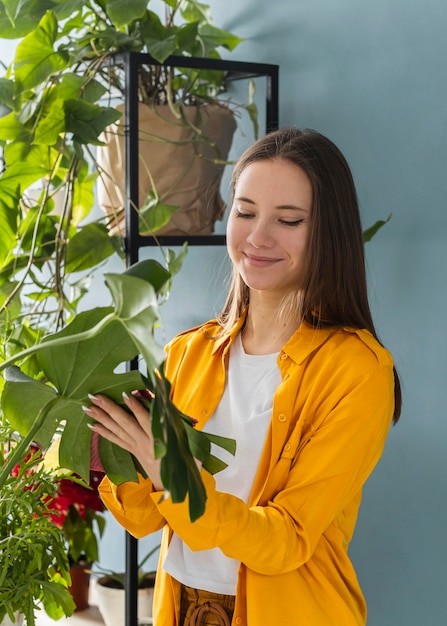 Foto mujer cuidando bien de las plantas de su casa