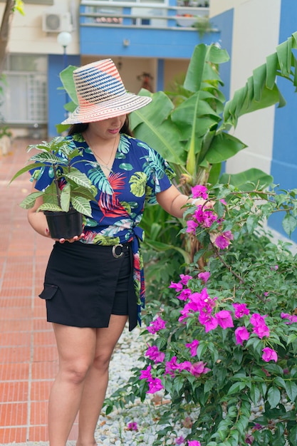 Mujer cuidando las plantas fuera de su casa. Jungla urbana