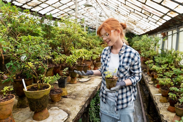 Foto mujer cuidando sus plantas en invernadero