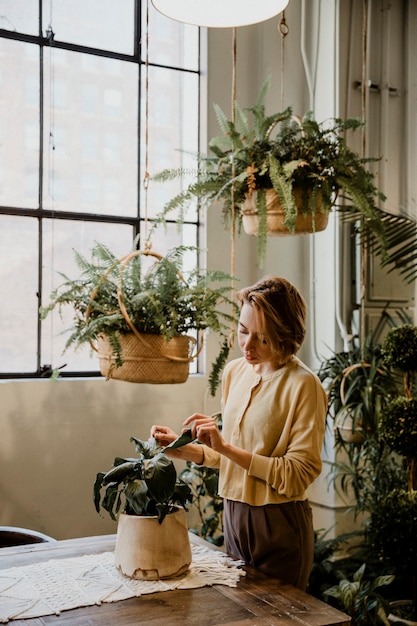 Mujer cuidando sus plantas en un invernadero
