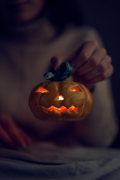 Mujer de cultivo mostrando jack o lantern de cerámica