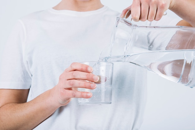 Foto mujer de cultivo que llena el vaso de agua