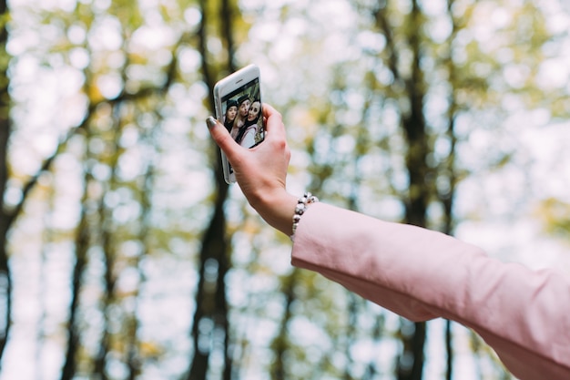 Mujer de cultivos tomando selfie con amigos