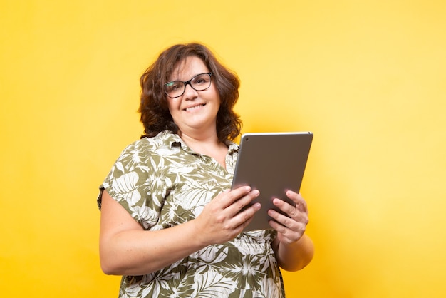 mujer curvilínea en tecnología de conducción de fondo amarillo