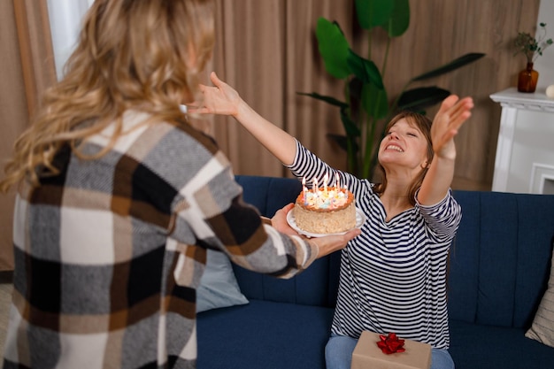 Mujer le da a su hija un pastel de cumpleaños