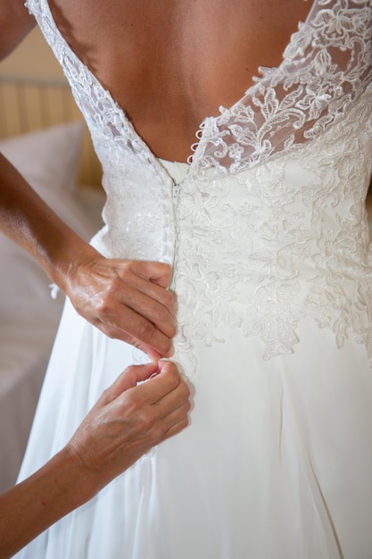 Mujer dama de honor preparando a la novia para el día de la boda