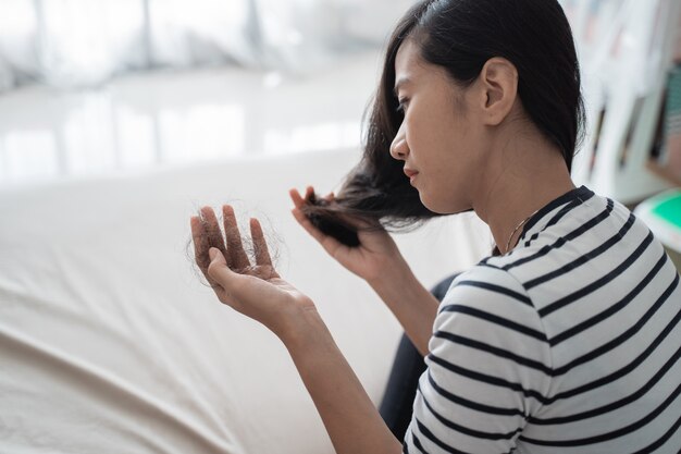 La mujer daña la pérdida de cabello