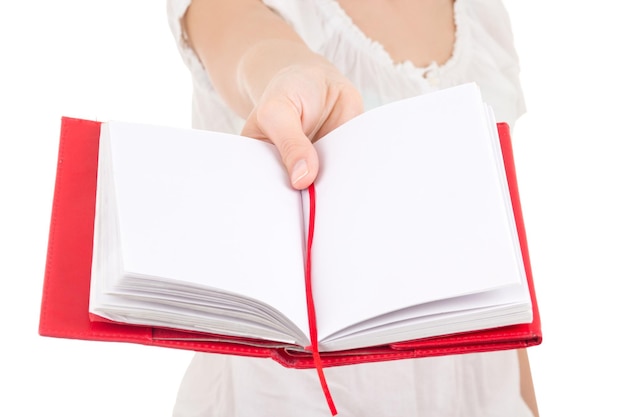 Mujer dando cuaderno en blanco aislado sobre fondo blanco.