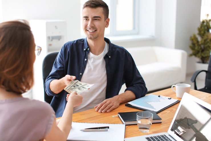 Foto mujer dando dinero al hombre en la oficina. concepto de forex