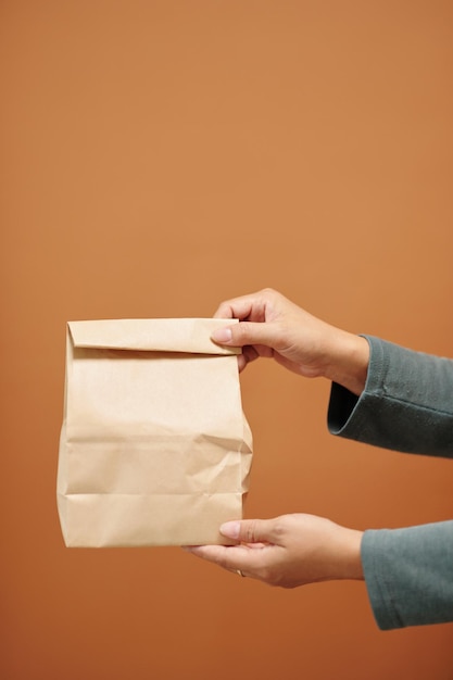 Mujer dando paquete de papel