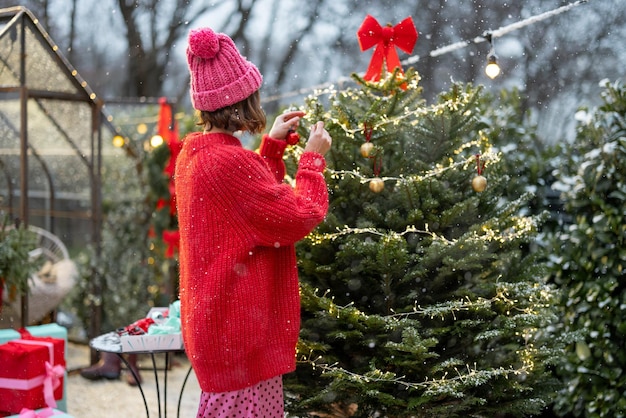 Mujer decora el árbol de navidad en bacyard