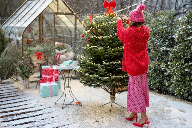 Mujer decora el árbol de navidad en bacyard