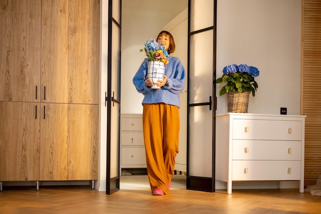 Mujer decora el interior de su casa con flores.