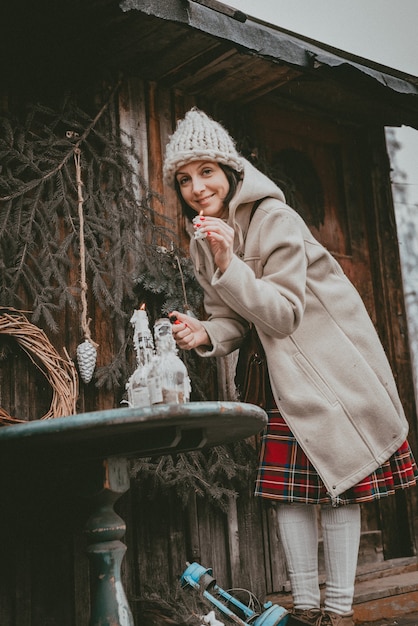 Mujer de decoración navideña crea un ambiente navideño al aire libre rústico minimalista moderno a partir de materiales ecológicos naturales de estilo escandinavo. Ideas para decorar año nuevo con tus propias manos hechas a mano.