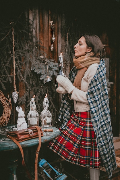 Foto mujer de decoración navideña crea un ambiente navideño al aire libre rústico minimalista moderno a partir de materiales ecológicos naturales de estilo escandinavo. ideas para decorar año nuevo con tus propias manos hechas a mano.