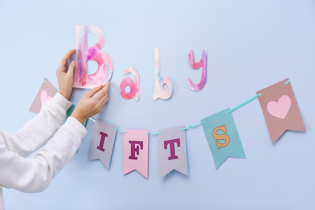 Foto mujer decorando la pared para la fiesta de baby shower en el interior