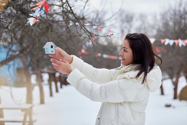 Mujer decorando el patio de su casa con juguetes hechos a mano Clima invernal fuera Tradiciones estacionales