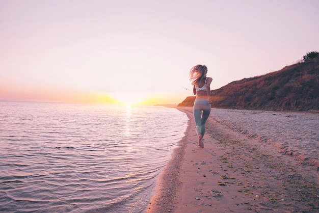 La mujer se dedica al ejercicio deportivo en la playa.