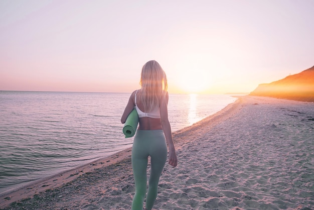 La mujer se dedica al ejercicio deportivo en la playa.