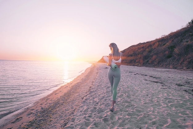 La mujer se dedica al ejercicio deportivo en la playa.