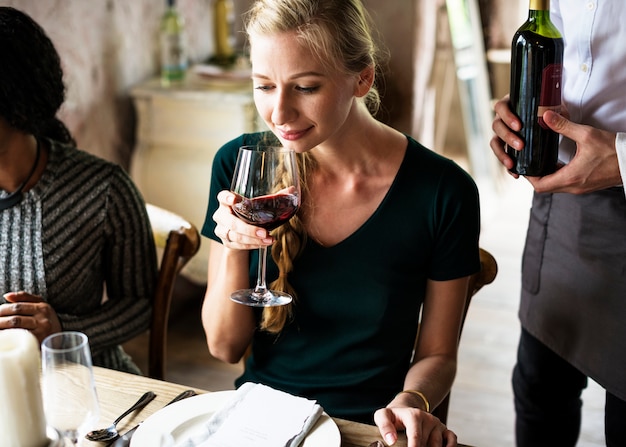 Mujer degustación de vino tinto en un restaurante con clase