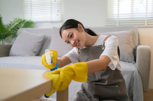 Una mujer con un delantal amarillo está limpiando una mesa