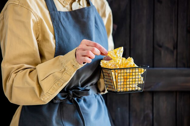 Mujer en un delantal tiene chips veganos saludables