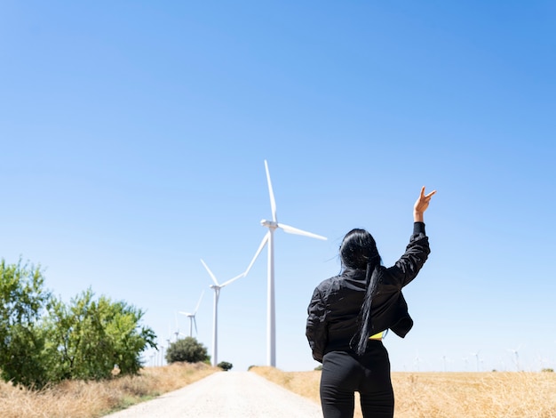 Mujer delante de la ecología de las turbinas eólicas